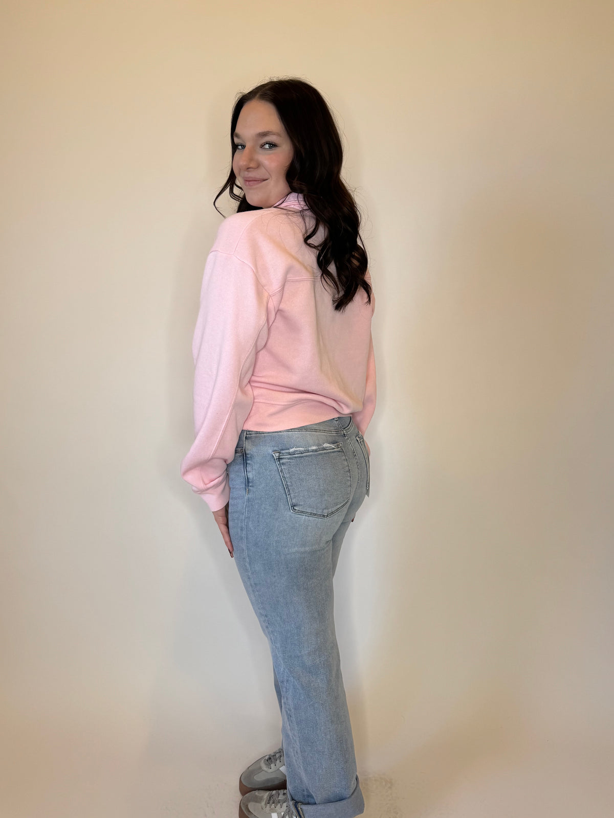 Trendy pink quarter-zip sweatshirt for women, featuring a soft fleece fabric, relaxed fit, and ribbed cuffs. Perfect for casual outfits, layering, and everyday wear. Styled with light-wash denim jeans for a cozy, fashionable look. Ideal for fall, winter, and spring fashion.