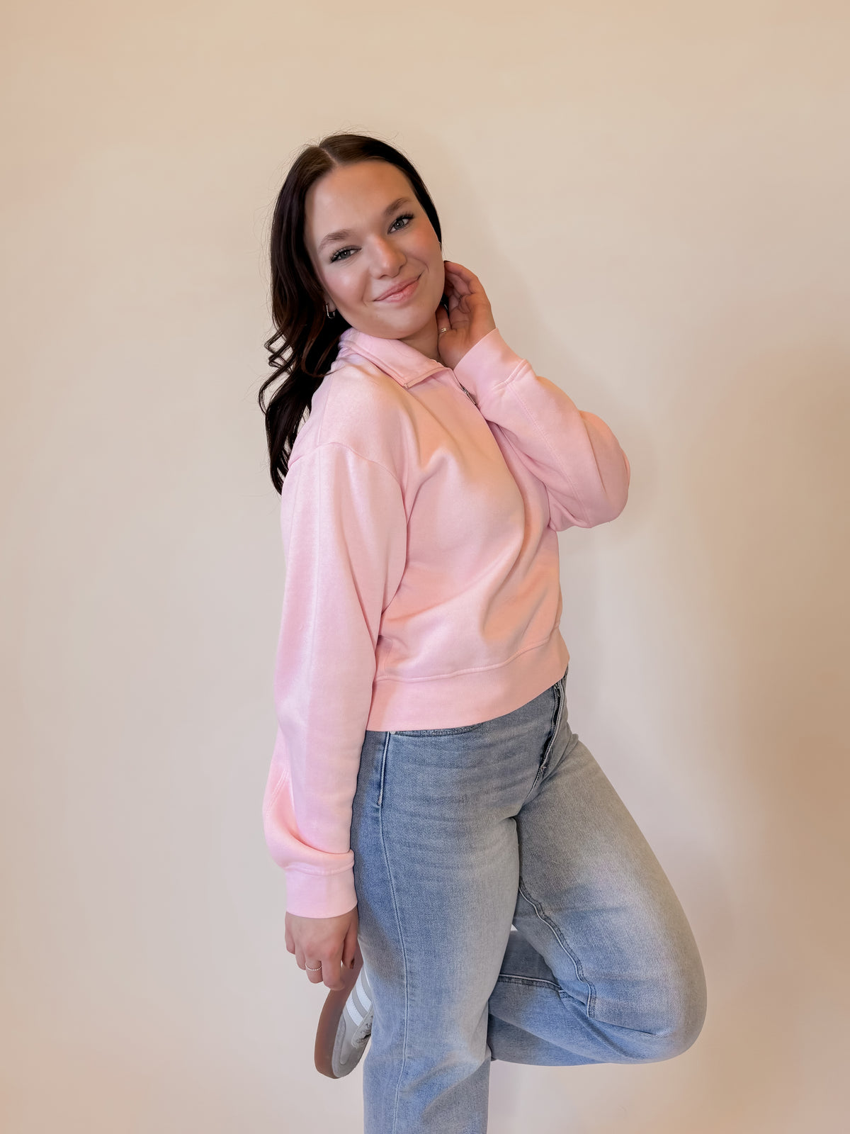 Trendy pink quarter-zip sweatshirt for women, featuring a soft fleece fabric, relaxed fit, and ribbed cuffs. Perfect for casual outfits, layering, and everyday wear. Styled with light-wash denim jeans for a cozy, fashionable look. Ideal for  spring fashion.