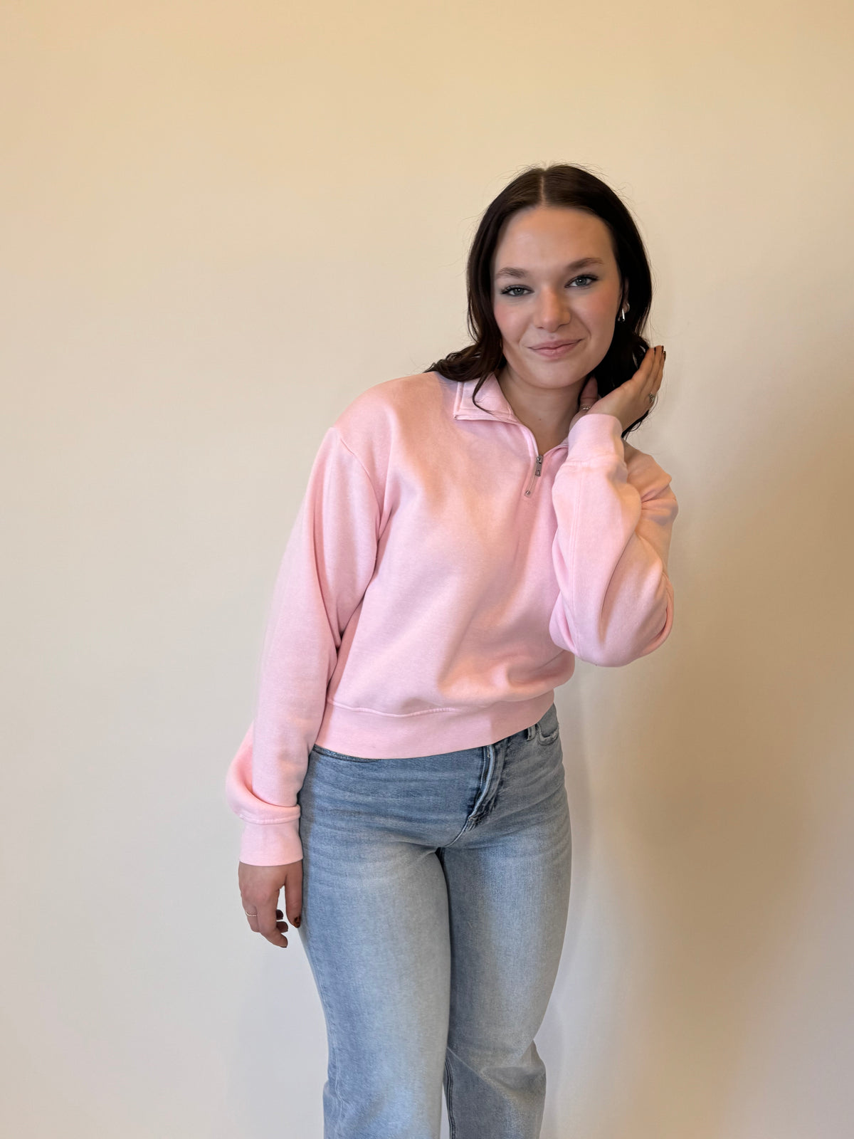 Trendy pink quarter-zip sweatshirt for women, featuring a soft fleece fabric, relaxed fit, and ribbed cuffs. Perfect for casual outfits, layering, and everyday wear. Styled with light-wash denim jeans for a cozy, fashionable look. Ideal for spring fashion.