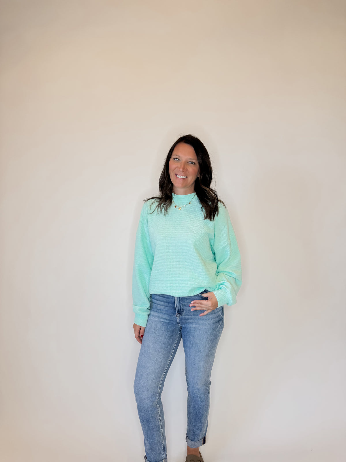 Women's aqua blue textured knit sweatshirt with a relaxed fit, long sleeves, and ribbed cuffs. Styled with classic blue jeans and neutral-toned shoes for a casual yet trendy look. Perfect for cozy everyday wear, layering, and seasonal fashion for fall, winter, and spring.